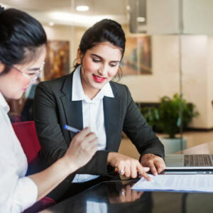 Indian female agent helping client sign the application document